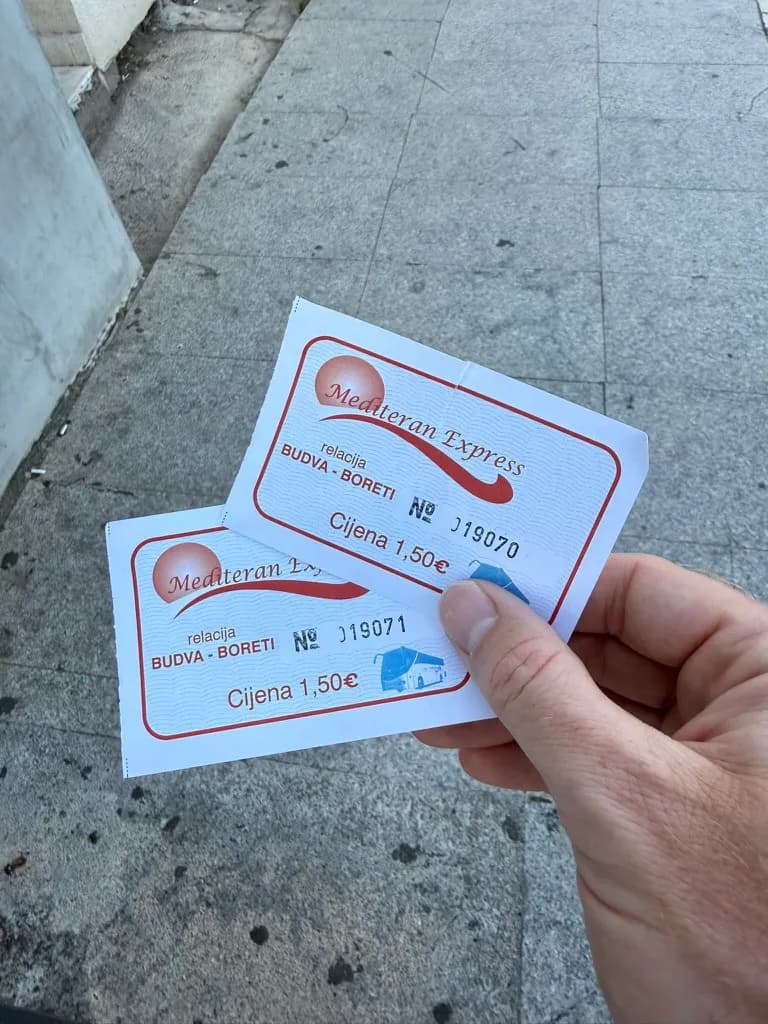Dwa papierowe bilety autobusowe Mediteran Express na trasę Budva–Boreti po 1,50 €, kupione za gotówkę u sprzedawcy na przystanku.
